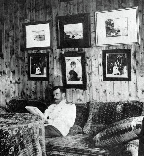 Император Николай II сидит на диване в своей комнате в охотничьем домике