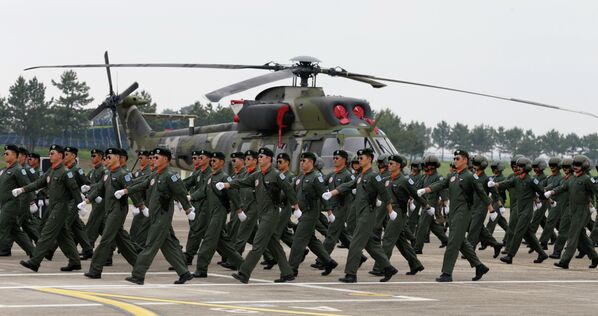 Пилоты маршируют мимо вертолета южнокорейской армии в Нонсане