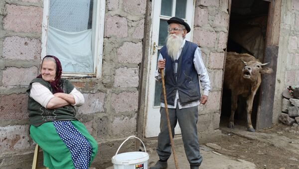 Пожилые молокане ожидают прихода скотины у своего дома в селе Лермонтово
