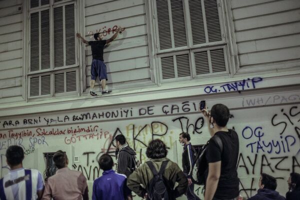 Один из протестующих на стене здания во время столкновения с сотрудниками полиции в Стамбуле