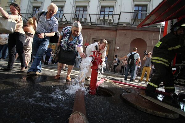 Пассажиры отмываются от копоти у станции метро Охотный ряд в центре Москвы, которую закрыли из-за пожара. Пассажиры отмываются от копоти у станции метро Охотный ряд в центре Москвы, которую закрыли из-за пожара.