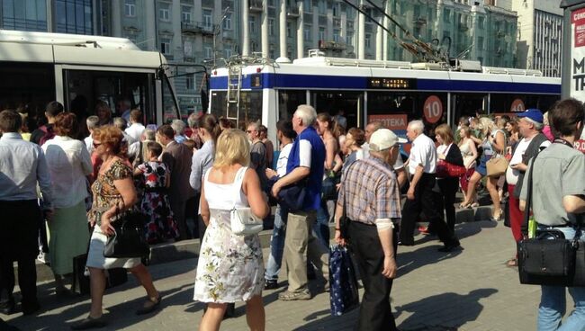 Люди садятся в общественный транспорт возле станции метро Парк культуры