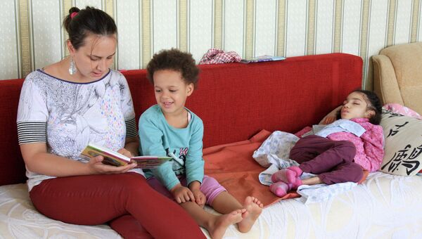 Социальный работник фонда Паллиативная помощь детям Наталья Малкина читает книжку Куне и Джулии