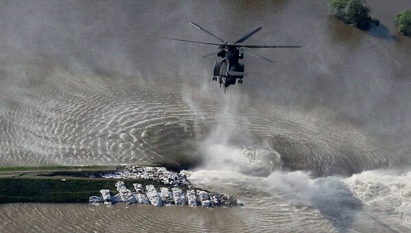 Вертолет сбрасывает мешки с песком на месте разрушенной дамбы в Германии