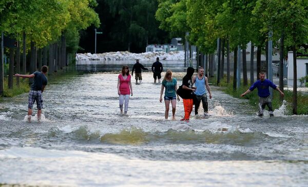 Люди идут по затопленной улице в городе Магдебург, Германия