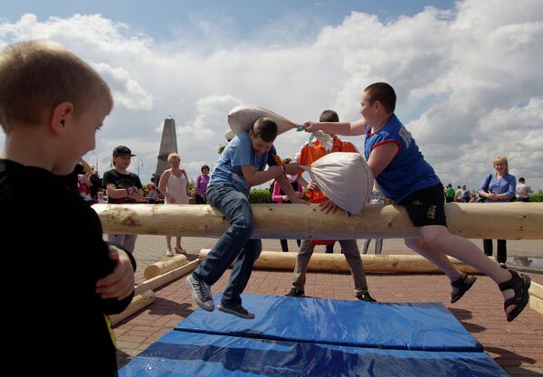 Дети участвуют в бое мешками во время празднования Дня России в Томске