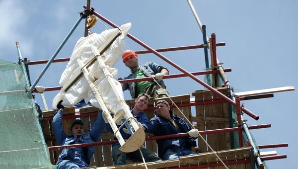 Рабочие монтируют воссозданный крест колокольни храма Софии премудрости божьей на Софийской набережной
