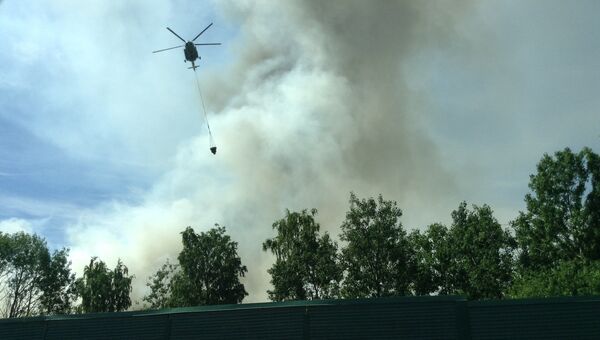 Вертолет тушит пожар на свалке в Ленинградской области