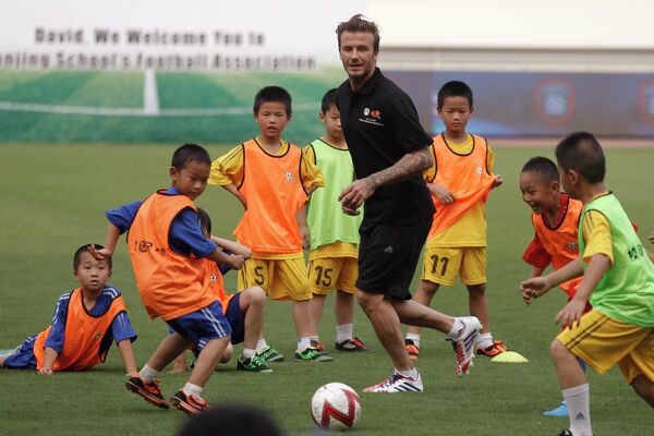 Дэвид Бекхэм играет в футбол с детьми