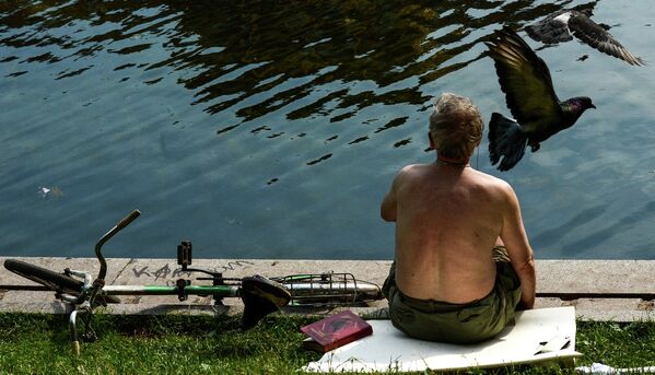 Мужчина отдыхает на Патриарших прудах в Москве
