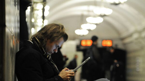 Пассажир пользуется планшетным компьютером на одной из станций Московского метрополитена. Архивное фото