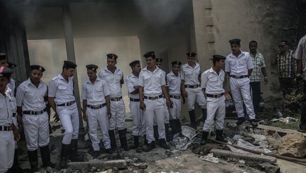 Полицейские в оцеплении у разгромленного здания штаб-квартиры политического движения Братья-мусульмане в Каире