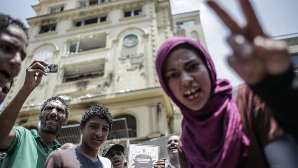 Протестующие у разгромленного здания штаб-квартиры политического движения Братья-мусульмане в Каире