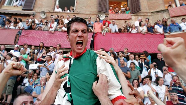 Жокей Джованни Атцени празднует победу в скачках Палио в Сиене