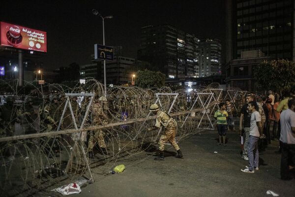 Военные устанавливают заграждения на дороге, разделяющей сторонников и противников президента Моххамеда Мурси в Каире