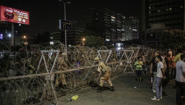 Военные устанавливают заграждения на дороге, разделяющей сторонников и противников президента Моххамеда Мурси в Каире