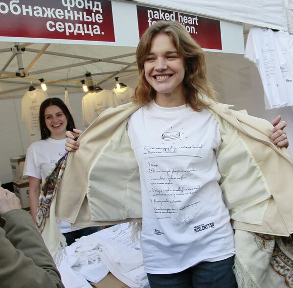 Российская топ-модель и общественный деятель Наталья Водянова демонстрирует футболку своего благотворительного фонда Обнаженные сердца