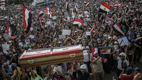 Участники митинга сторонников президента Мохаммеда Мурси держат картонные гробы, символизирующие погибших в столкновениях с армией