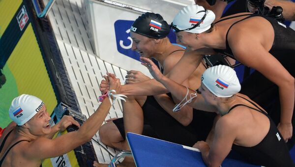 Команда России на финише дистанции эстафеты 4х100 м комплексом в финальных соревнованиях по плаванию