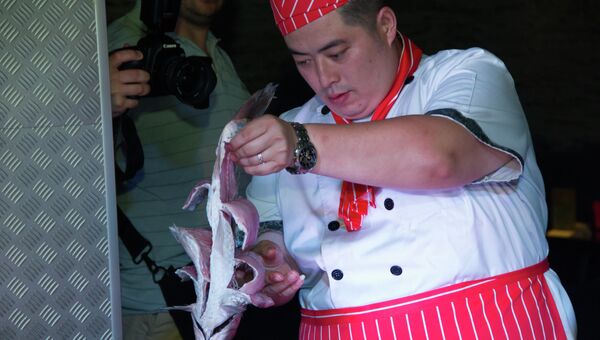 Китайский повар готовит рыбу на мастер-классе во Владивостоке