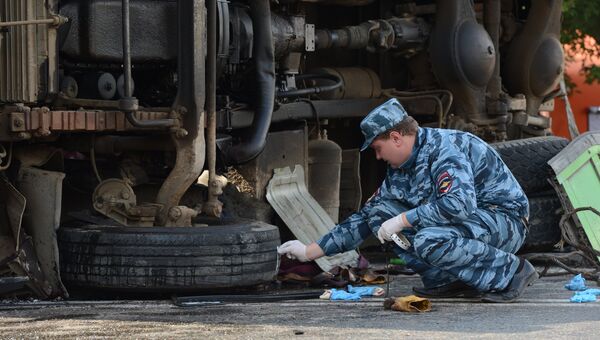 Сотрудник полиции работает на месте столкновения рейсового автобуса с КАМАЗом.