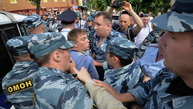 Сотрудники полиции задерживают участника несанкционированного шествия