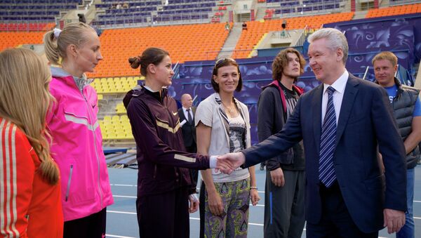 Сергей Собянин (справа на первом плане) общается с тренерами и спортсменами-легкоатлетами на стадионе Лужники