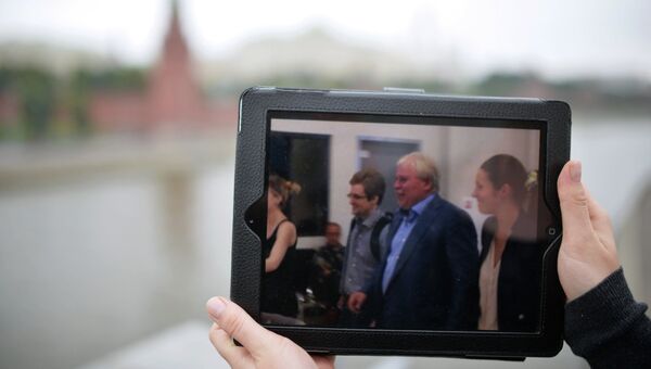 На экране планшета фотография момента, как экс-сотрудник ЦРУ Эдвард Сноуден в сопровождении адвоката Анатолия Кучерены покидает здание аэропорта Шереметьево, архивное фото