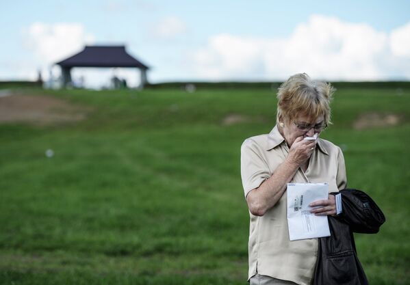 Родственница погибшего воина из Германии плачет на немецком военном кладбище у города Духовщин