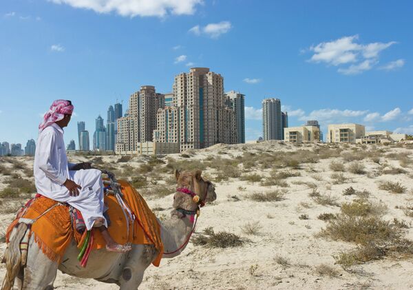 Бедуин на верблюде на фоне города Дубай