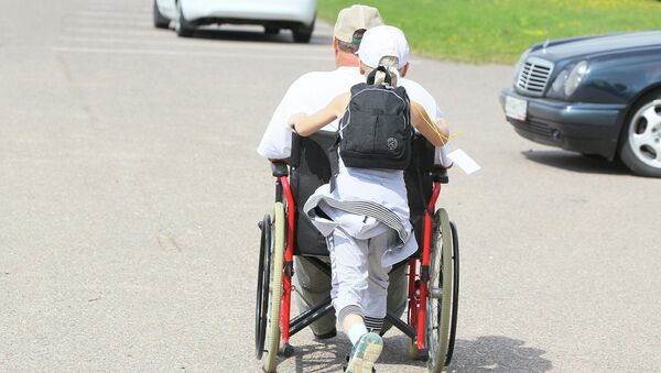 Человек, сопровождающий инвалида. Архивное фото