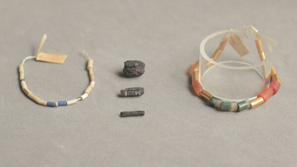 Бусины из метеоритного железа (в центре) составляли ожерелье вместе с бусинами из лазурита, сердолика, агата и золота