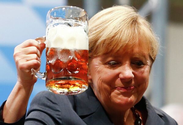Канцлер Германии Ангела Меркель пьет пиво во время предвыборной встречи