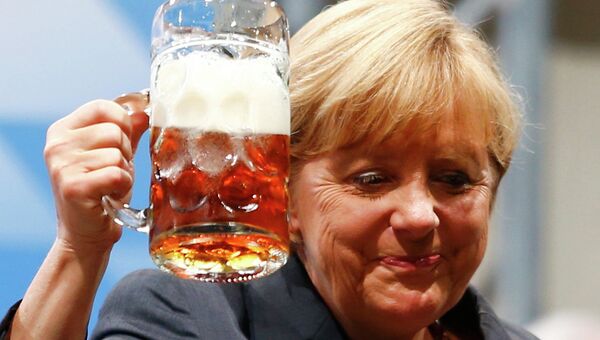 Канцлер Германии Ангела Меркель пьет пиво во время предвыборной встречи