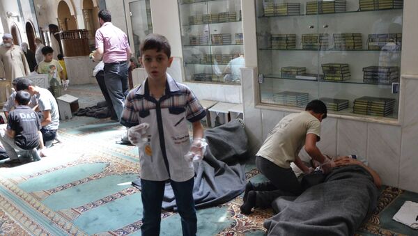 Люди помогают постадавшим от газовой атаки в мечети в окрестностях Дамаска
