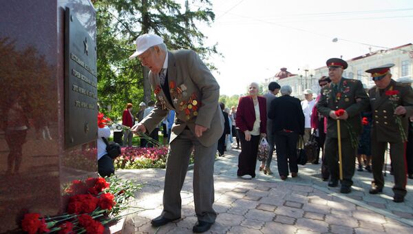 Ветеран возлагает цветы к стеле в честь подвига томичей в Великой Отечественной войне.