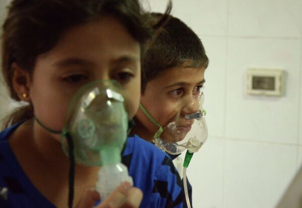 Дети дышат через кислородные маски после газовой атаки в пригороде Дамаска