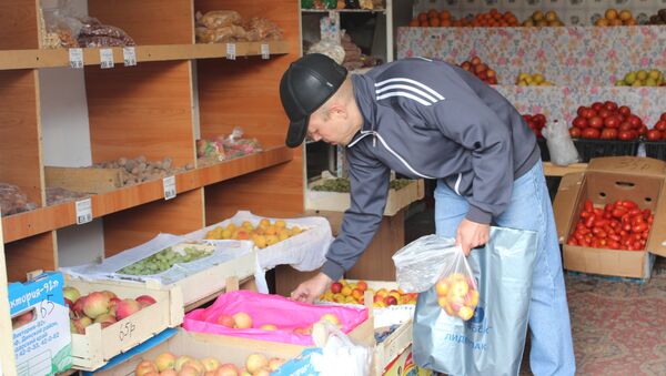 Мужчина выбирает фрукты на рынке. Архивное фото