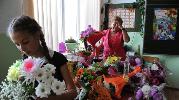 Учительница с букетами цветов в первый день нового учебного года в гимназии. Архивное фото