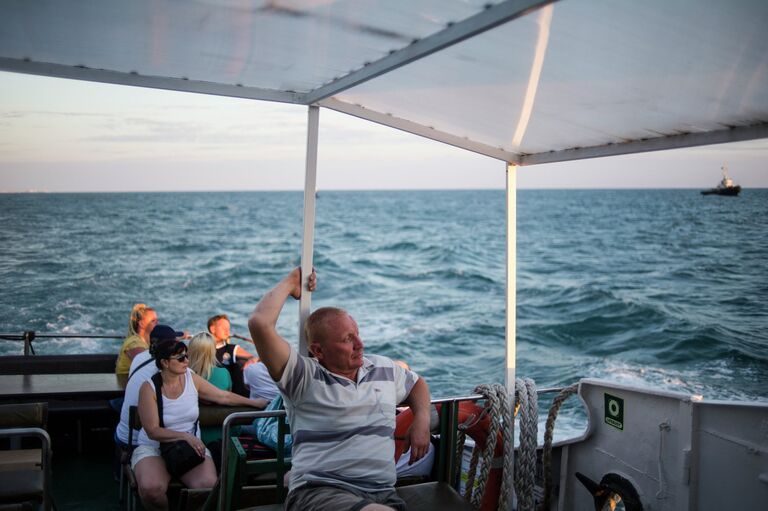 Отдыхающие во время морской прогулки вдоль сочинского побережья