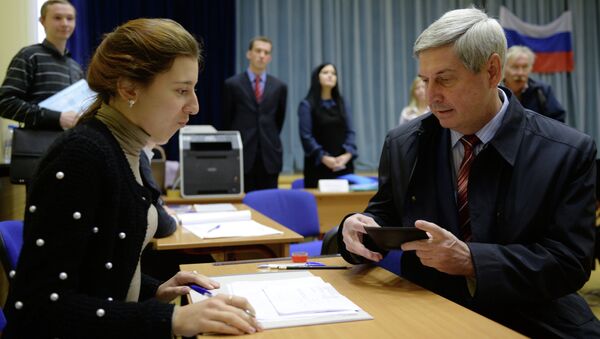 Иван Мельников регистрируется перед голосованием на избирательном участке.
