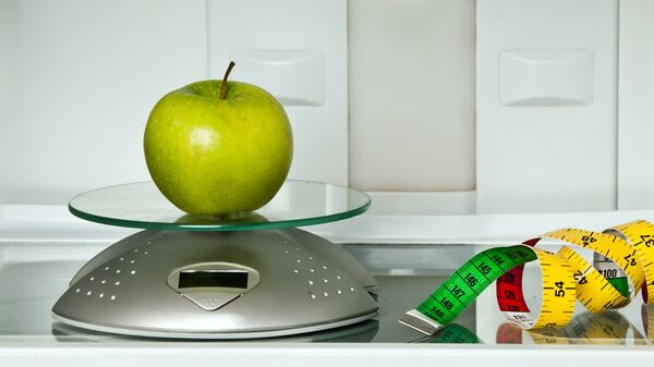 Яблоко и сантиметр в холодильнике