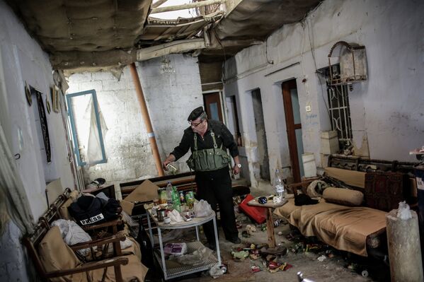 Командир отряда ополченцев в одном из домов, освобожденном от боевиков, в центре города Маалюля