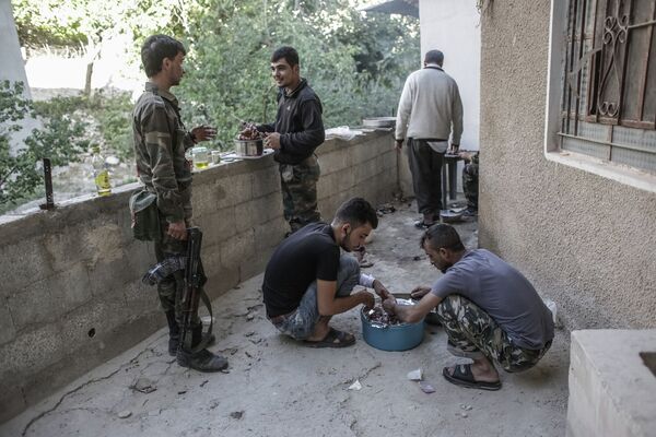 Солдаты готовят шашлык на заднем дворе одного из домов в центре Маалюли