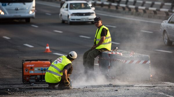 Рабочие ремонтируют дорогу
