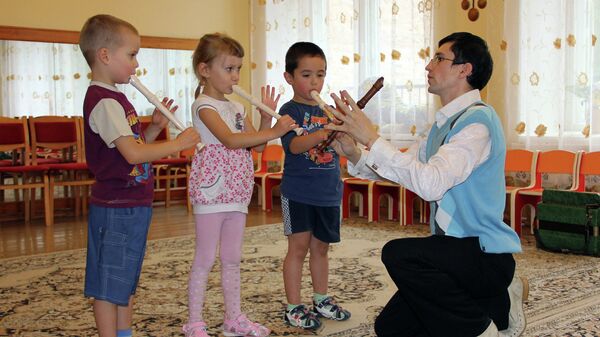 Томский преподаватель музыки Алексей Пашков учит детей игре на флейте, архивное фото