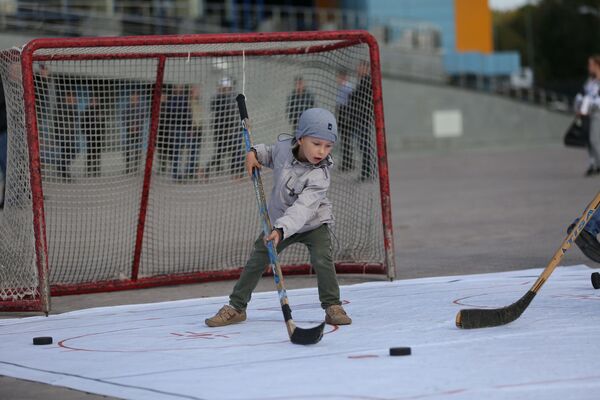 Ребенок играет в хоккей на площадке перед КСК Фетисов-Арена во Владивостоке
