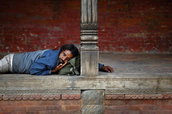 Мужчина спит в храме Пашупатинатх в Катманду