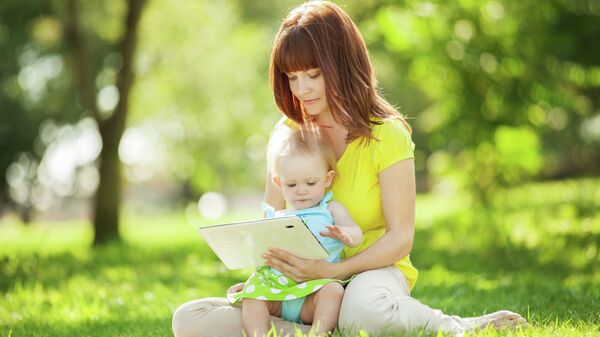 Женщина показывает ребенку видео на планшете. Архивное фото