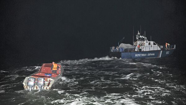 Корабль береговой охраны (справа) буксирует лодку браконьеров. Архивное фото